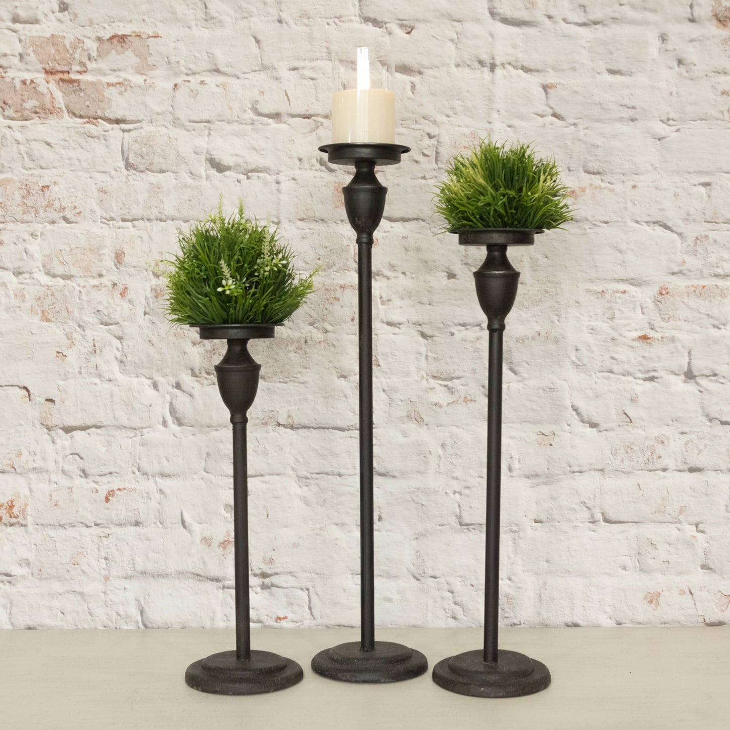 Ondrea Black Metal pillar candlestick, set of three on antiqued brick background | Hugo George Home