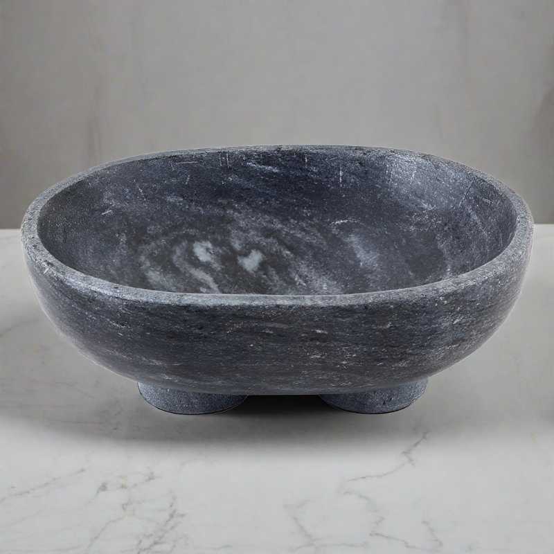 Charcoal marble footed bowl on a white marble countertop with gray background